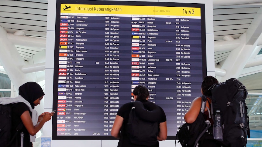 Foreign tourists check their flight information at Bali's International Airport and almost all flights are no longer operating.