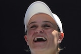 A female tennis player laughs after she won a match at the Australian Open.