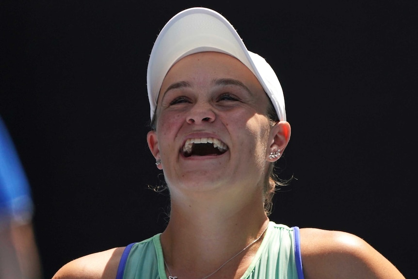 A female tennis player laughs after she won a match at the Australian Open.