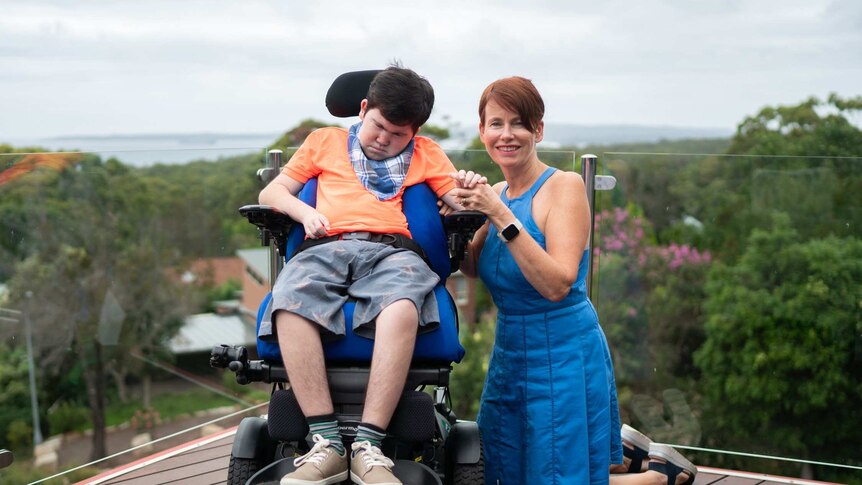 Annnette Pham and her son Liam, who is in a wheelchair, at their home in Vincentia