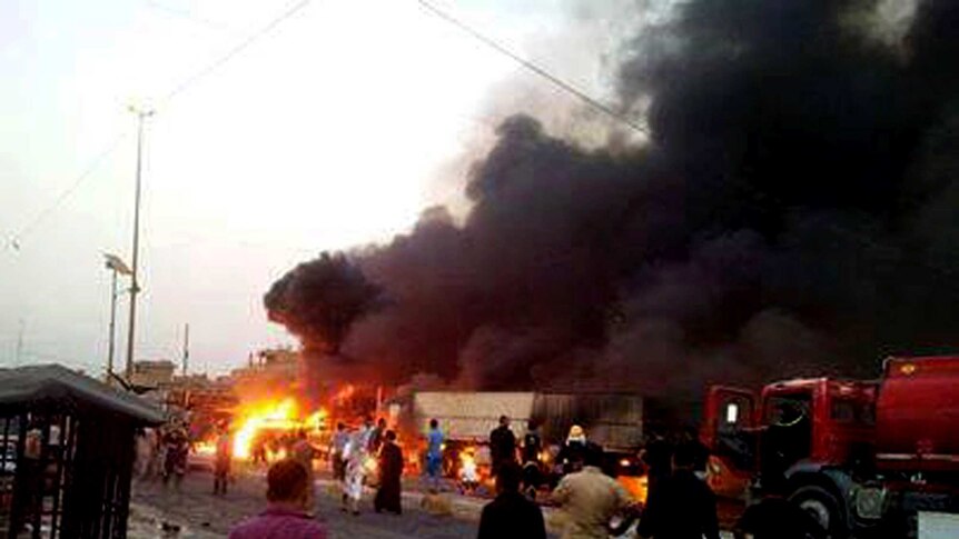 Black smoke fills the air following explosions at a funeral tent in the Sadr City district of Baghdad on September 21, 2013.