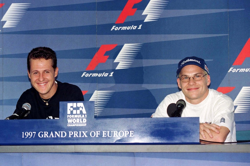 Two racing drivers at a pre-race press conference.