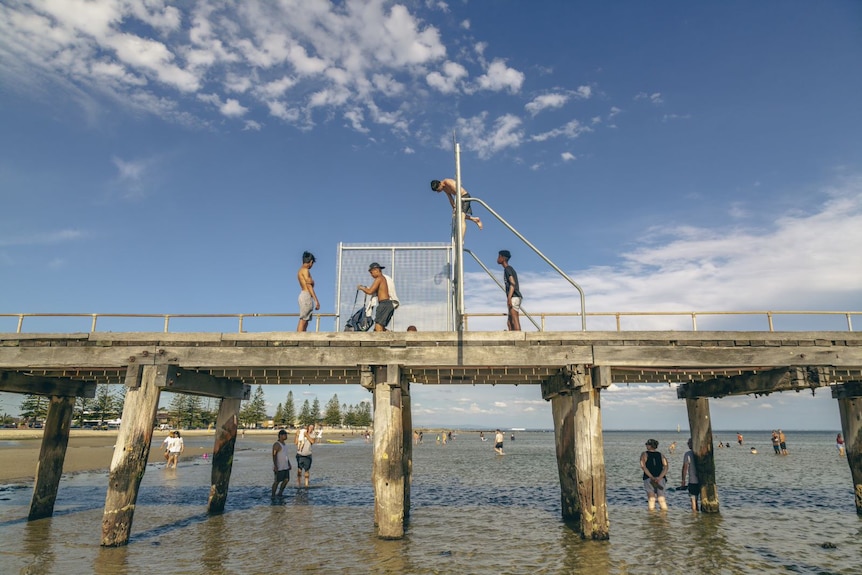 Children play on a pier in the sun.