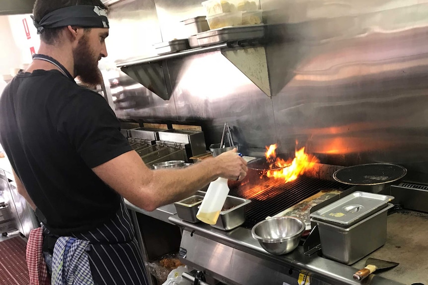 A chef works in the kitchen of barbecue joint Elwoods Eatery in Orange