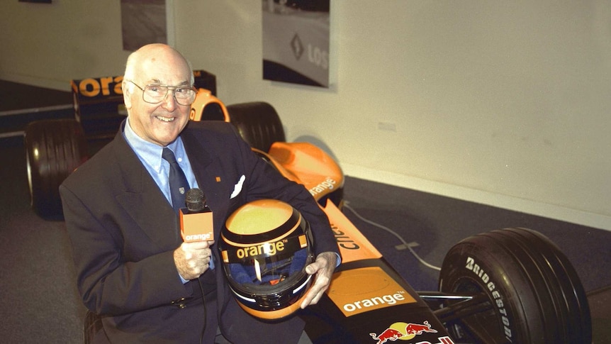 Ex commentator Murray Walker poses for the cameras next to an F1 car