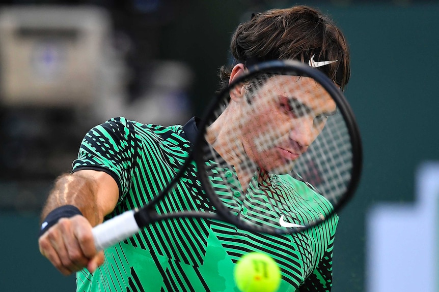 Roger Federer returns against Rafael Nadal