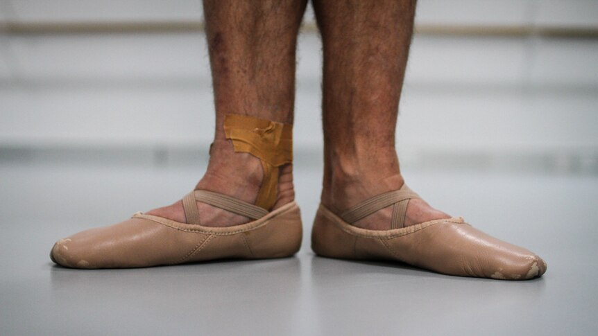 A close up of mechanical plumber Paul Scott's feet in ballet shoes.