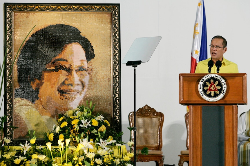 Benigno Aquino da un discurso junto a una foto de su madre, la fallecida presidenta Corazón Aquino.