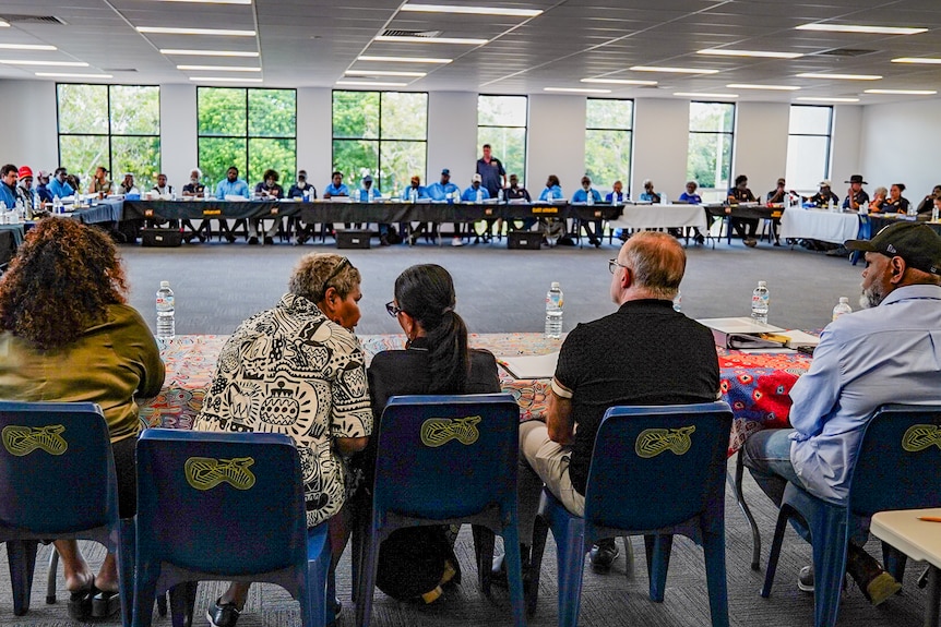 a group of people sitting at tables in a room. 