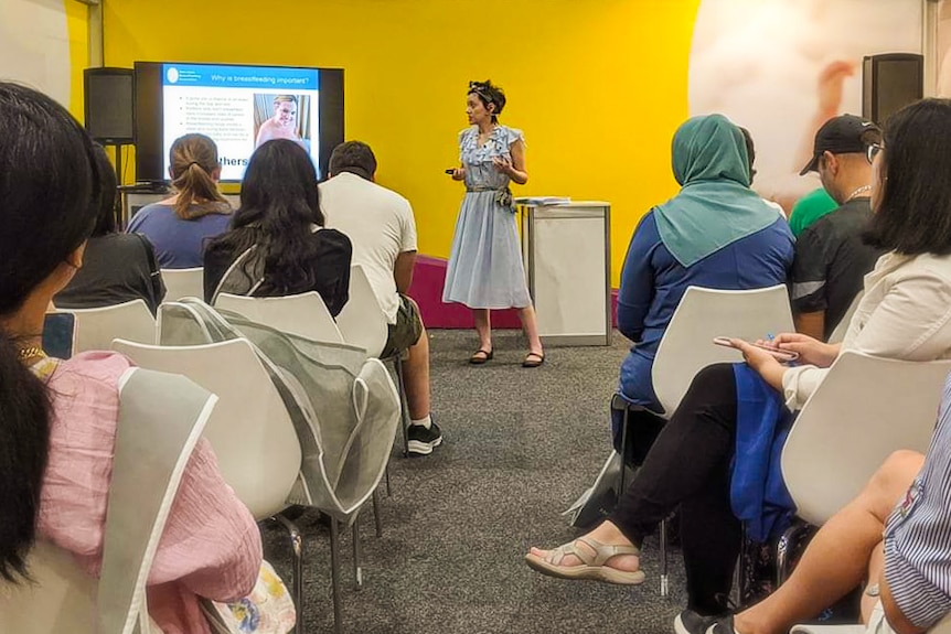 woman presenting to a room full of women. 