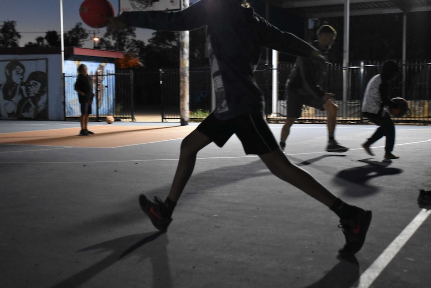 Young people play basketball in a youth centre in Alice Springs