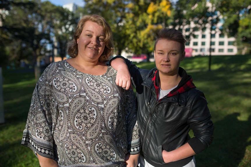 Kai leans against his mother, Yolanda