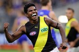 Maurice Rioli smiles with his mouth wide open and clenches his right fist