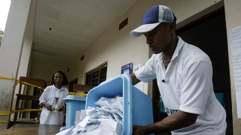 An electoral worker empties a ballot box at a polling station in Dili.