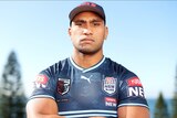 A man stares at the camera while wearing a rugby league jersey