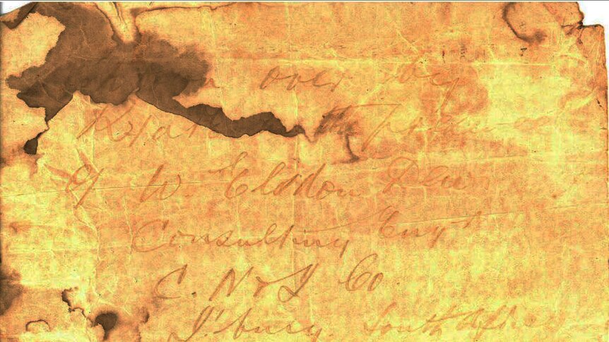 A scanned image of a water-damaged piece of paper with a faded hand-written note.