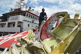 An Indonesian worker cuts the tail of the AirAsia flight after debris from the crash was retrieved.