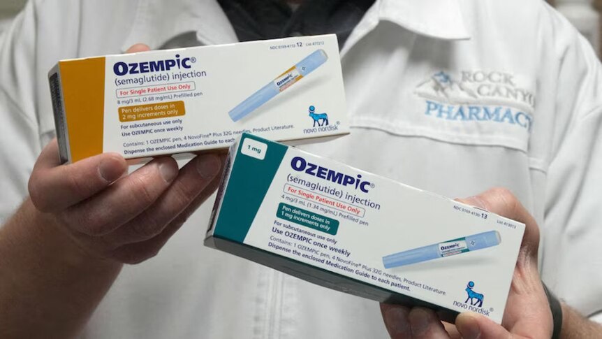 Close up of Ozempic boxes being held up by an unseen pharmacist.