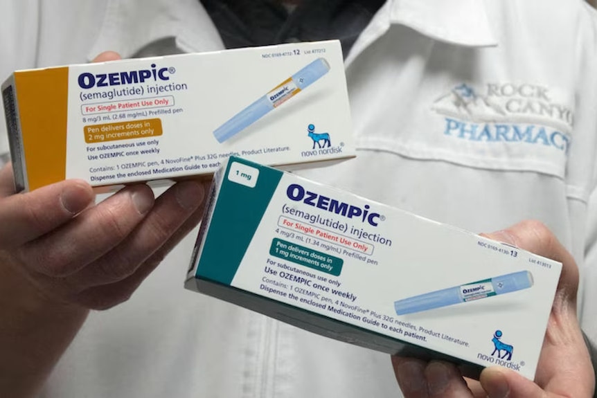 Close up of Ozempic boxes being held up by an unseen pharmacist.