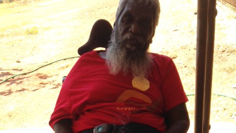 A man in a wheelchair with a cake.