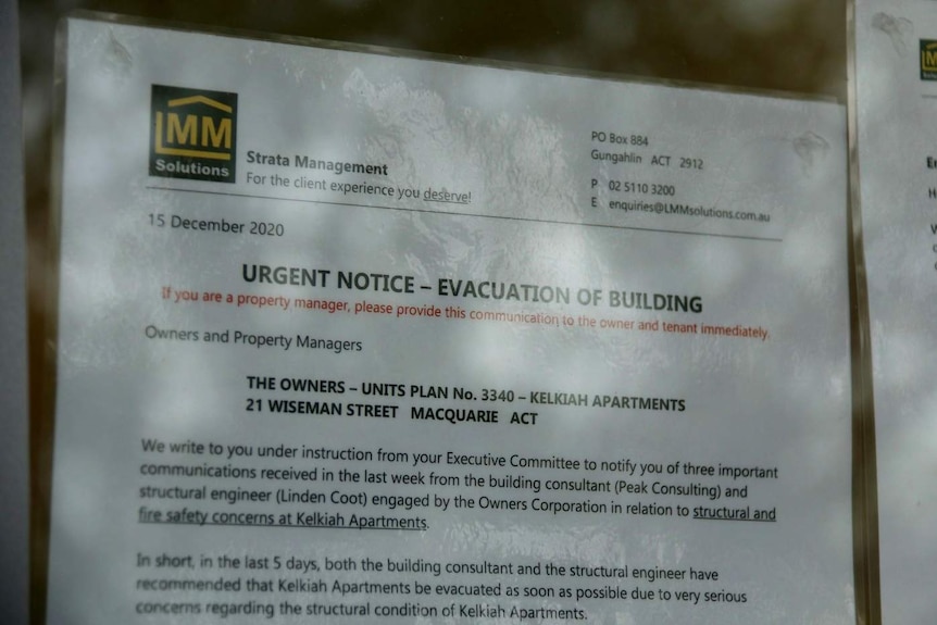 A laminated notice posted onto an apartment wall warns residents to evacuate.