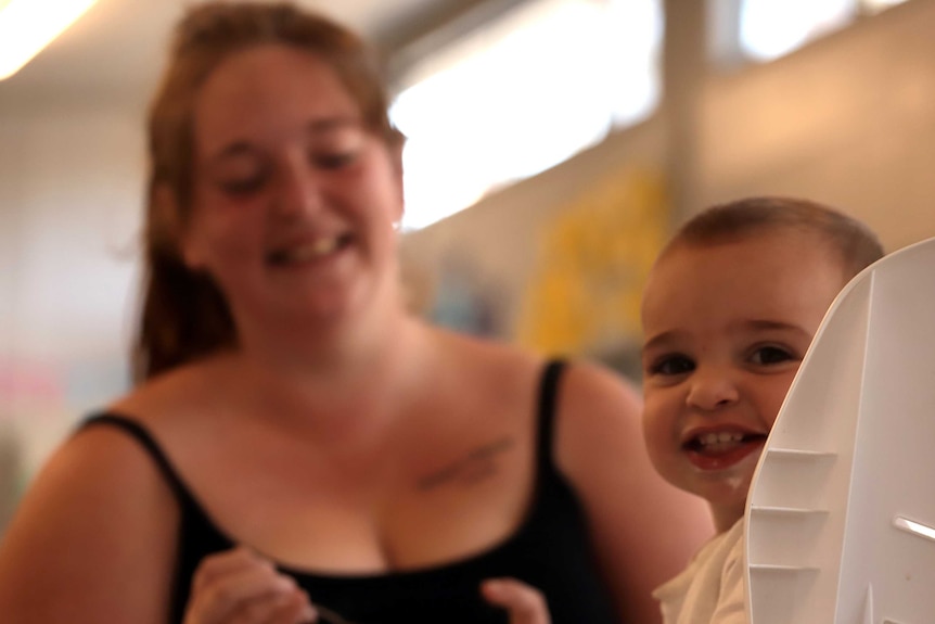 A baby is fed in a high chair