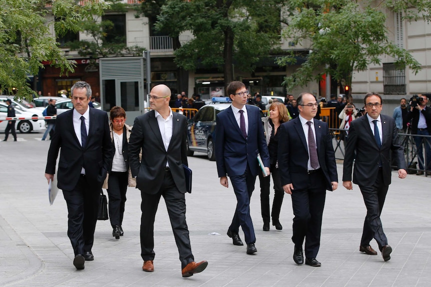 Fired Catalan Cabinet members walk towards the High Court.
