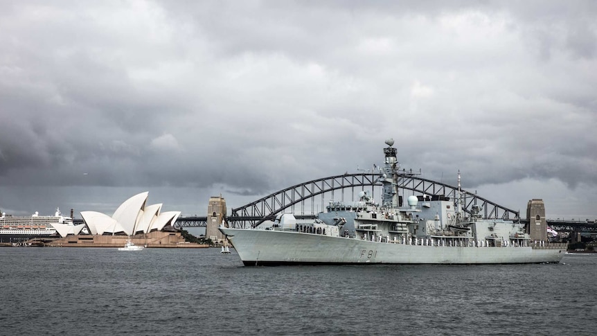 The HMS Sutherland is seen in Sydney Harbour next to the Sydney Opera House.