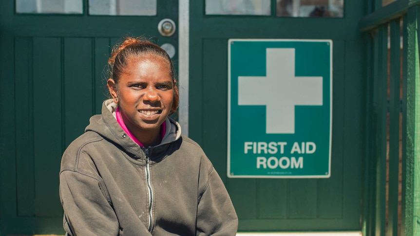 Nerissa Narburup sitting in front of a health service's first aid room.
