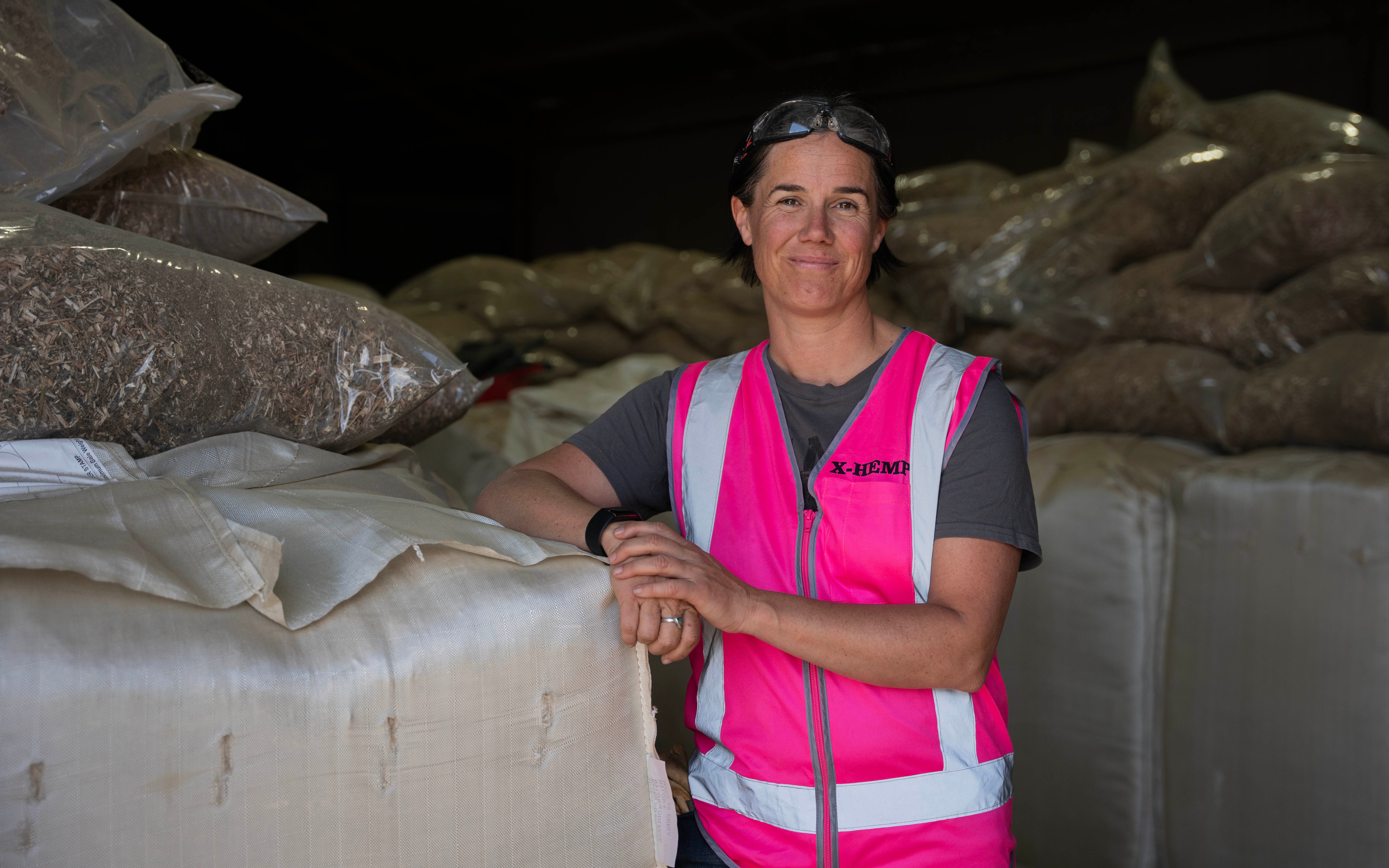Portrait of a lady in a pink high-vis vest looking at the camera.