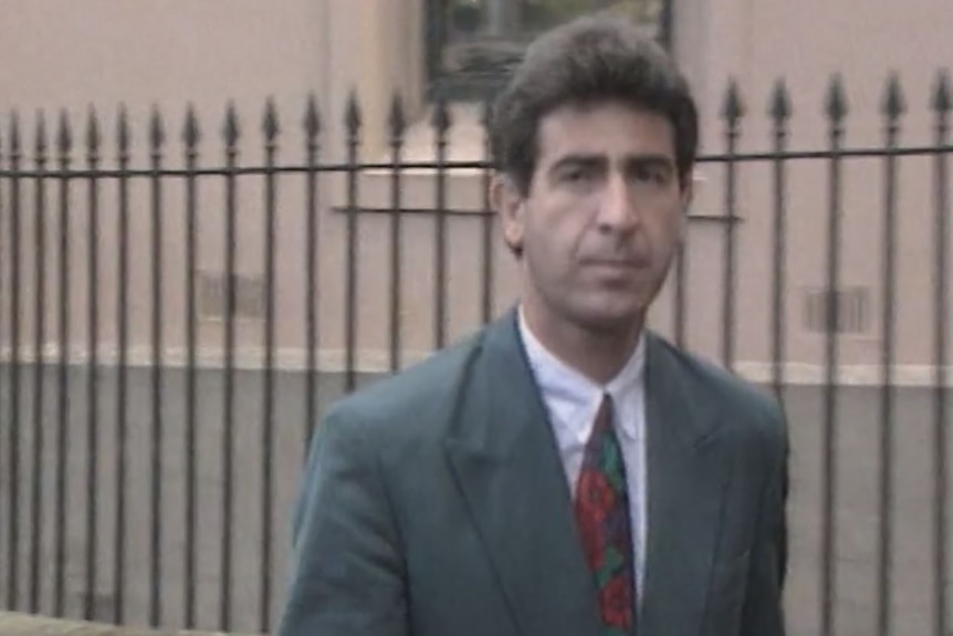 A man wearing a suit walks into court