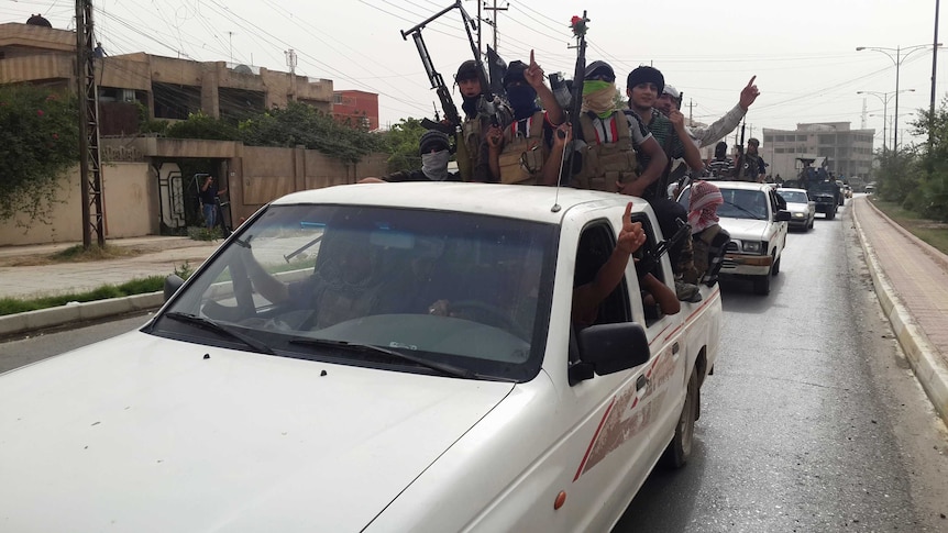 ISIS fighters celebrate on vehicles in Mosul