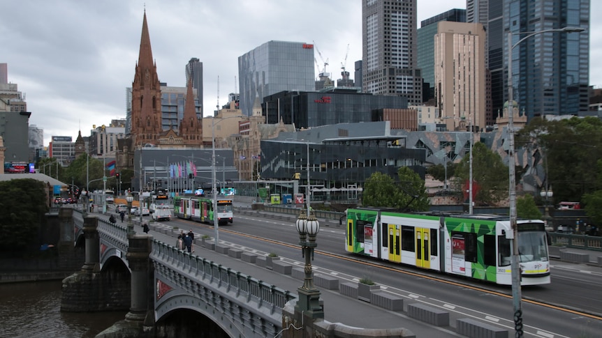 A view of Melbourne's CBD, with trams running and people on footpaths.