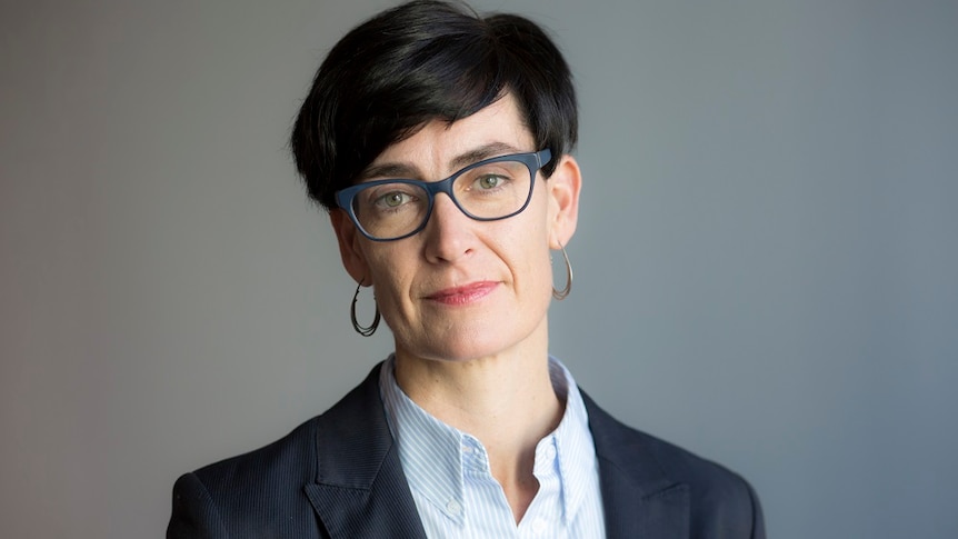 A head shot of Commissioner Liana Buchanan who has short black hair and wears glasses.