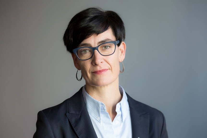 A head shot of Commissioner Liana Buchanan who has short black hair and wears glasses.