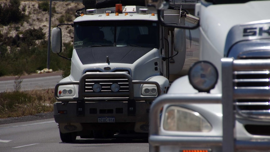 Two trucks travel along Roe Highway in Perth.