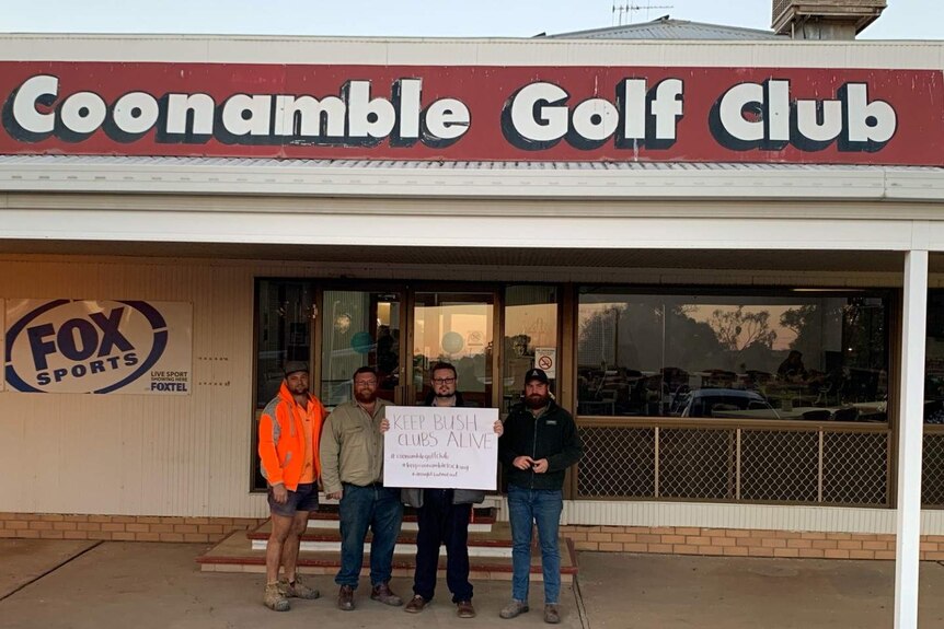 Four men hold a sign outside a building that says Coonamble Golf Club