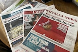 Local newspapers laid on on a table.