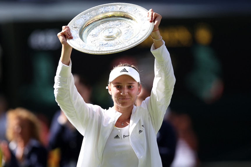 Elena Rybakina holds a trophy aloft.