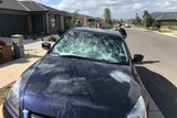 A car's front windshield is smashed by partygoers in Werribee.