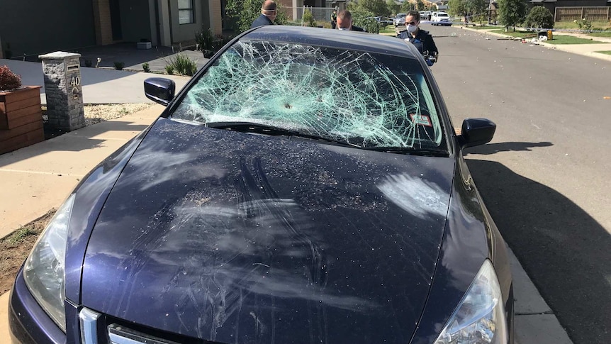 A car's front windshield is smashed by partygoers in Werribee.