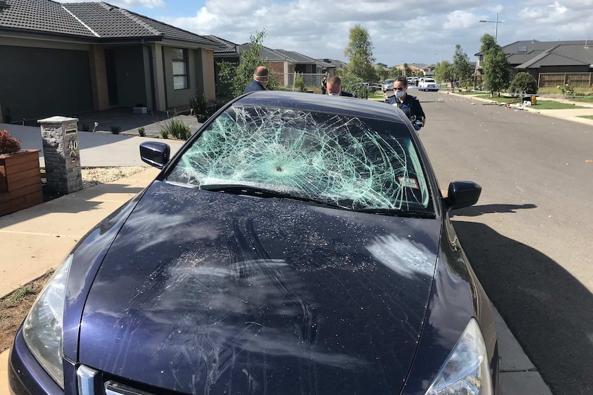 A car's front windshield is smashed by partygoers in Werribee.