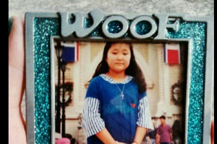A picture of a young girl in a photo frame that says 'woof dog'