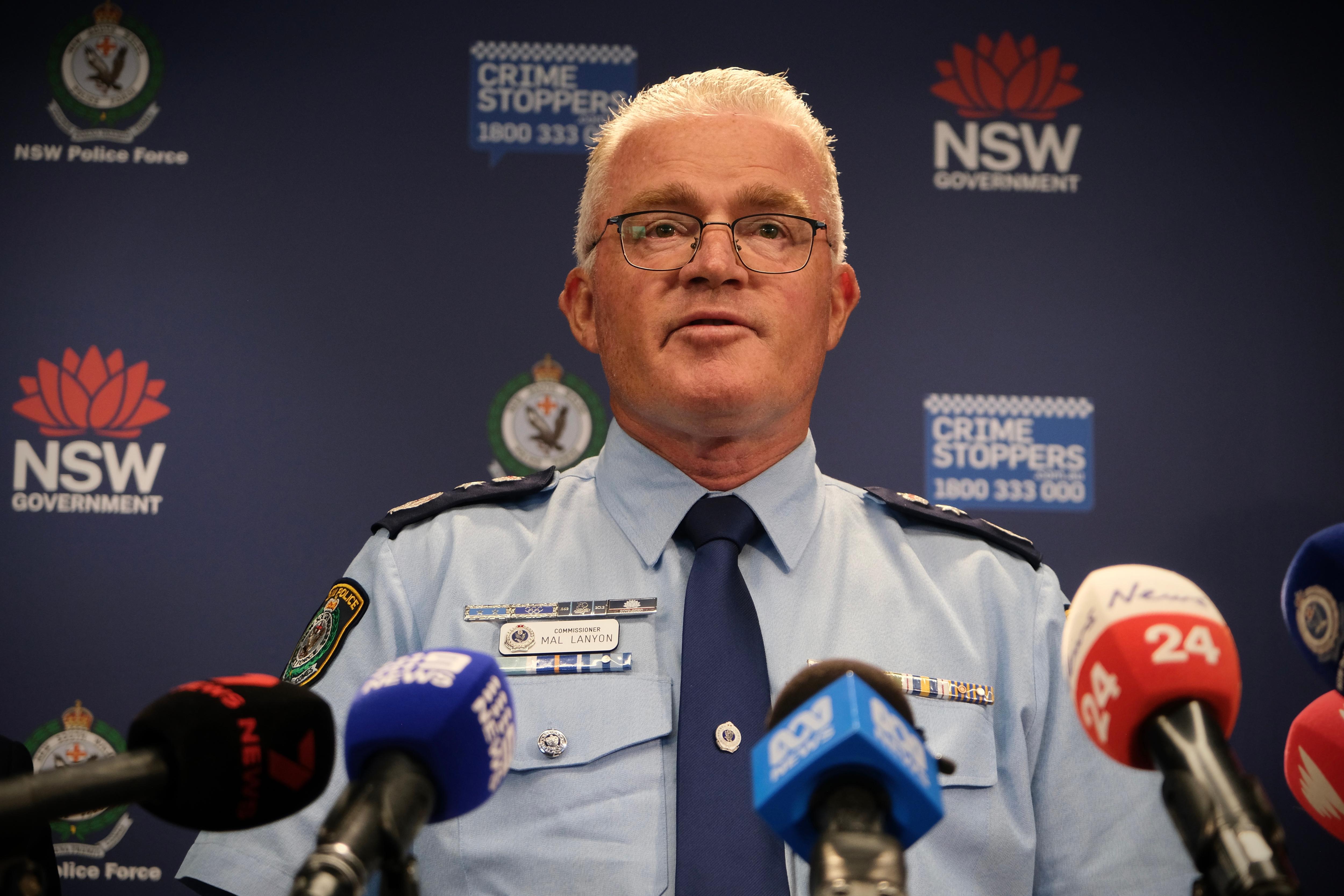 The police commissioner stands at a podium to address media.