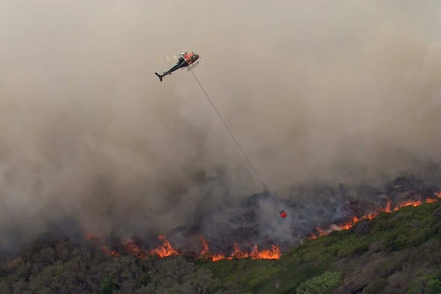 Helicopter water bombing over fire