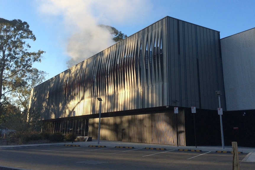 The rectangular grey NCI building, with steam billowing from the roof.