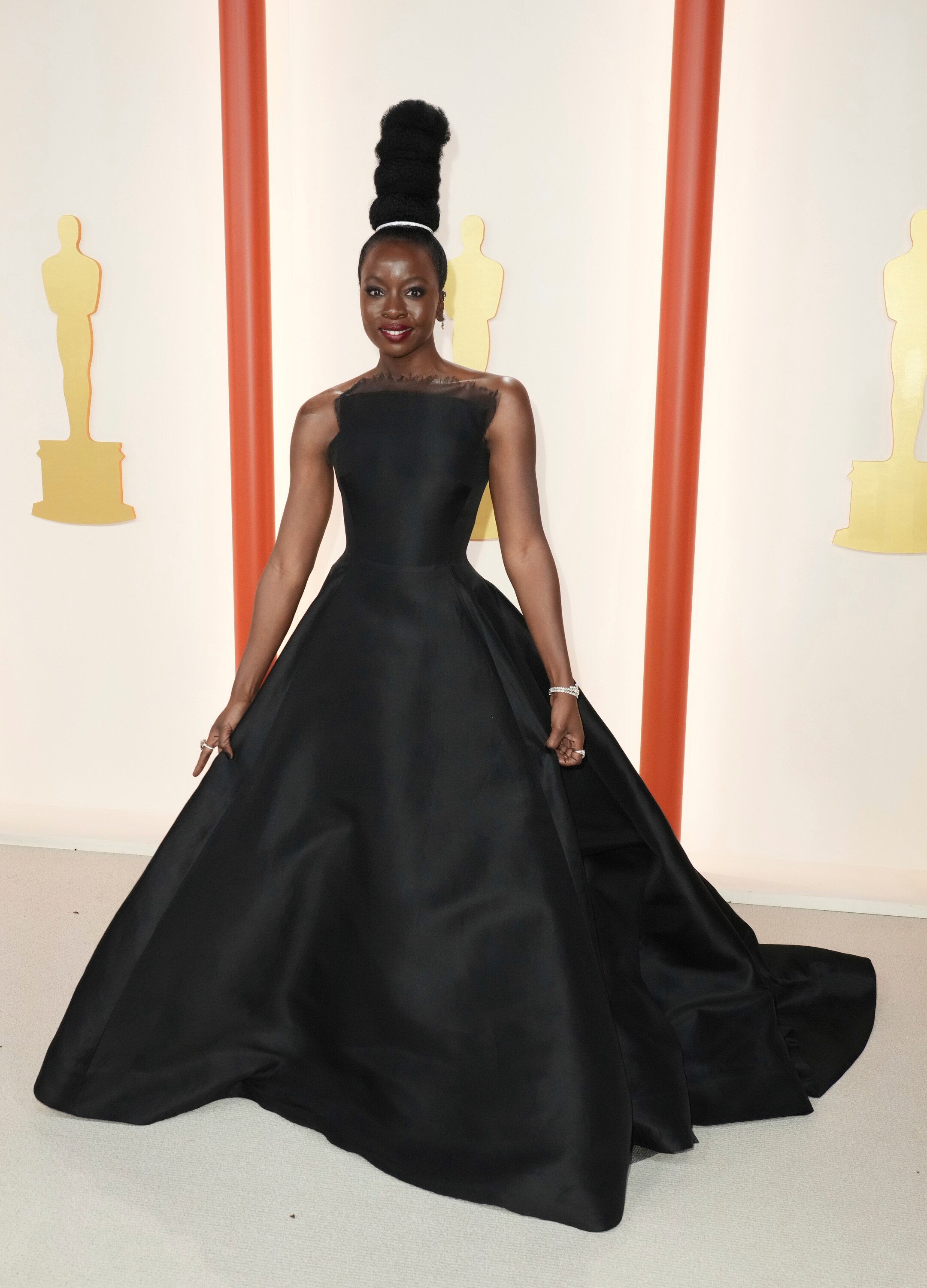 Danai Gurira wearing a strapless black floor-length gown with a structure bodice and a full, voluminous skirt