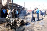 Officials inspect the remains of a vehicle used in a bomb attack in Kut in August 2011.
