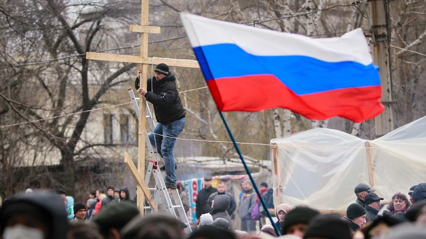 Man decorates cross during pro-Russian rally