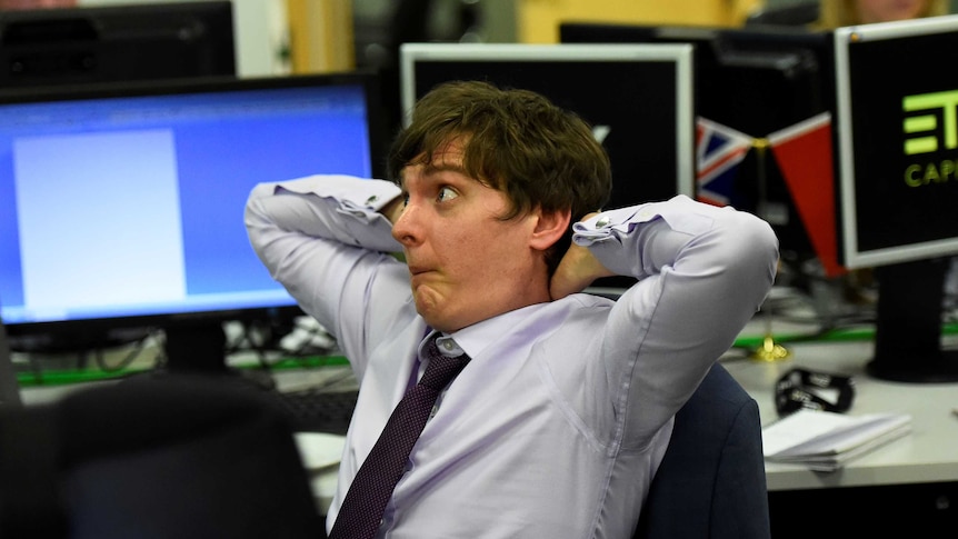 A trader leans back in his chair and reacts with dismay at the exit polls in favour of a labour majority.